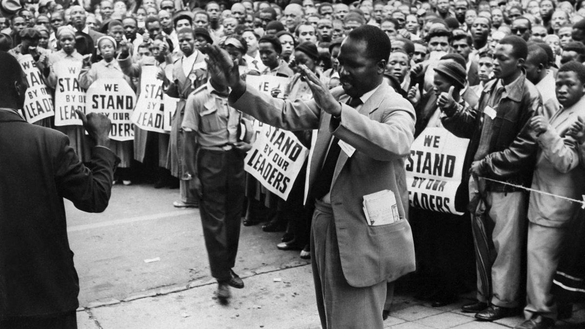 Nelson Mandela leading a peaceful protest, raising his fist as a symbol of unity and resistance.