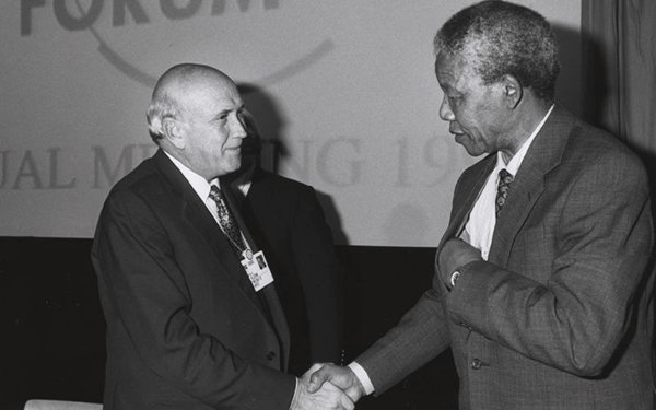 Nelson Mandela and President F.W. de Klerk shaking hands, signifying the historic negotiations that paved the way for a democratic South Africa.